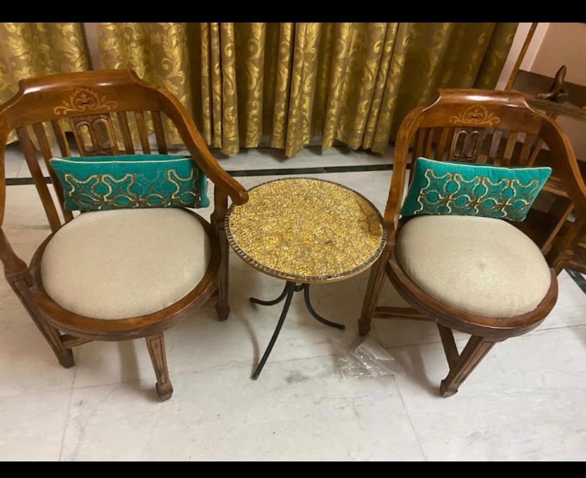 Pair of carved wooden chairs with round side table